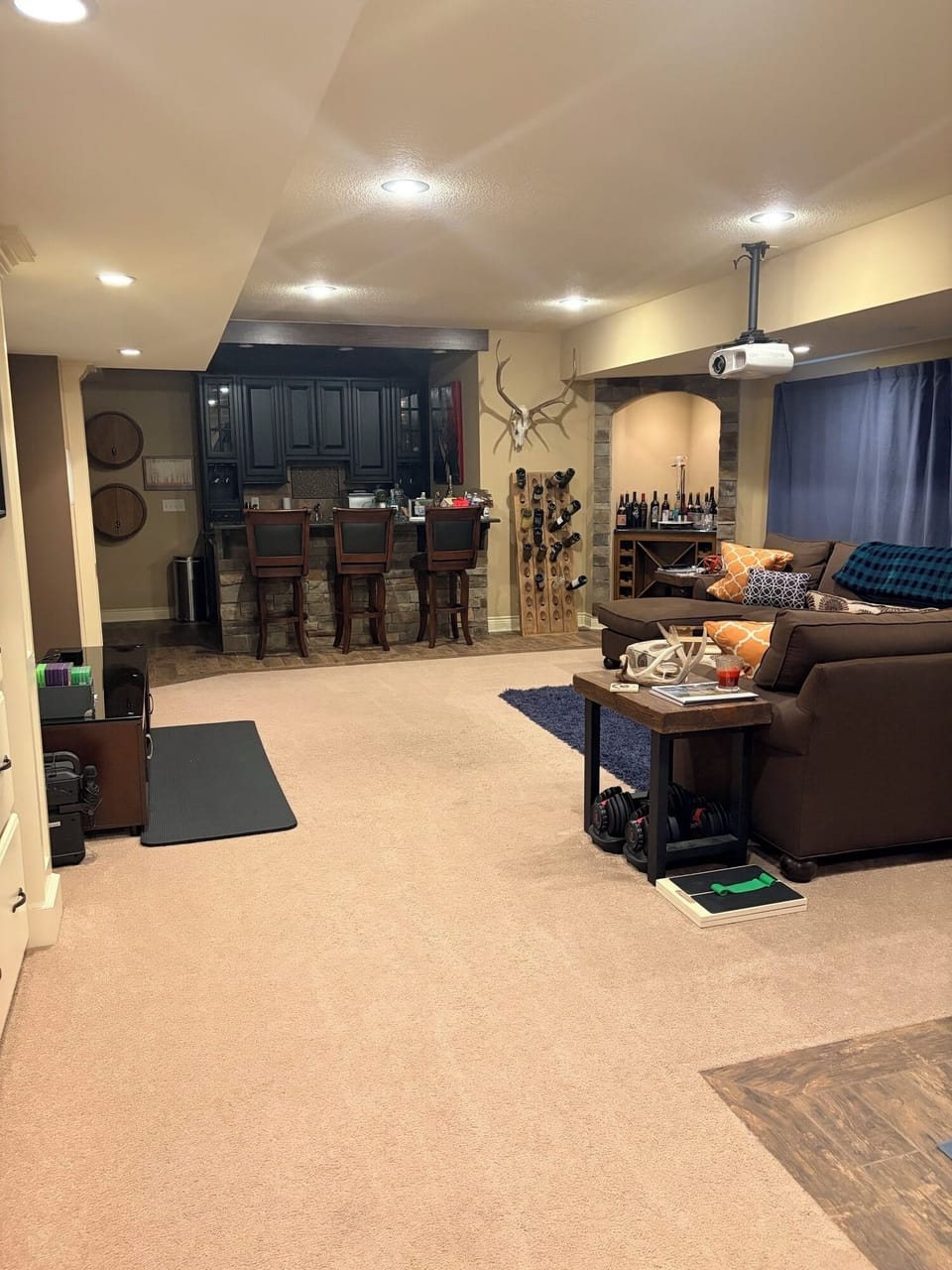 Finished basement with sectional couch, bar area and 90' projection TV