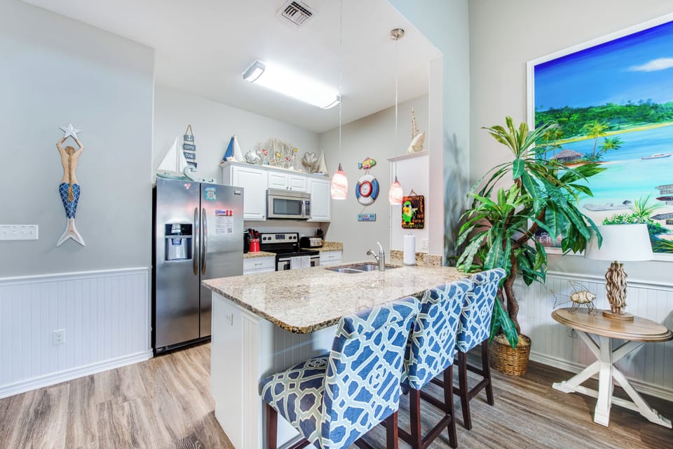 Your coastal-themed kitchen invites culinary adventures with granite counters, modern appliances, and charming nautical touches that make you feel right at home.