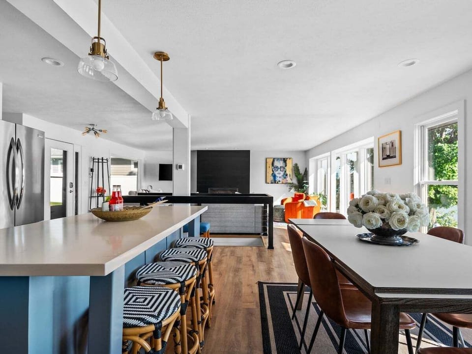 Open-concept kitchen and dining area with bar seating and bright views into the living space.