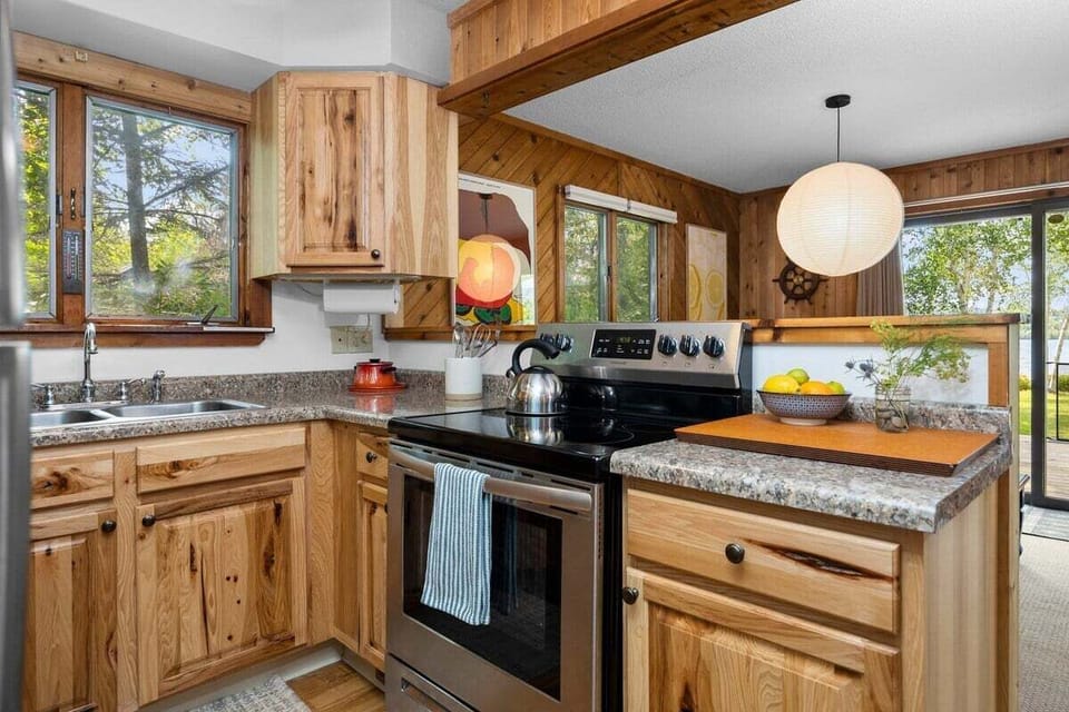 Cozy kitchen with warm wood cabinetry, lake views, and everything needed for easy meals at the cabin.