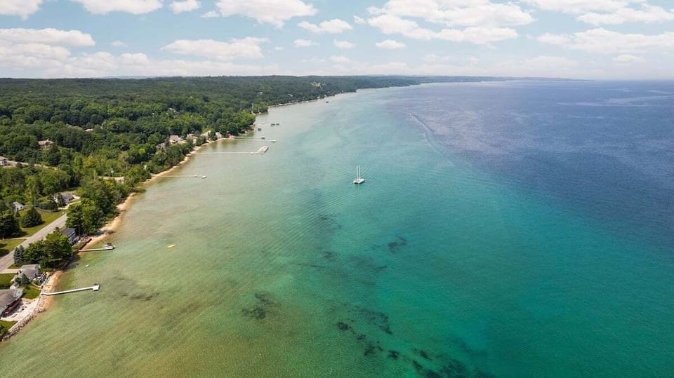 Endless shoreline and crystal-clear waters 🌊

Take in sweeping views of the sparkling bay, where turquoise water meets lush green coastline. Whether you're boating, swimming, or simply soaking in the scenery, this stunning stretch of shoreline is what northern Michigan summers are all about.