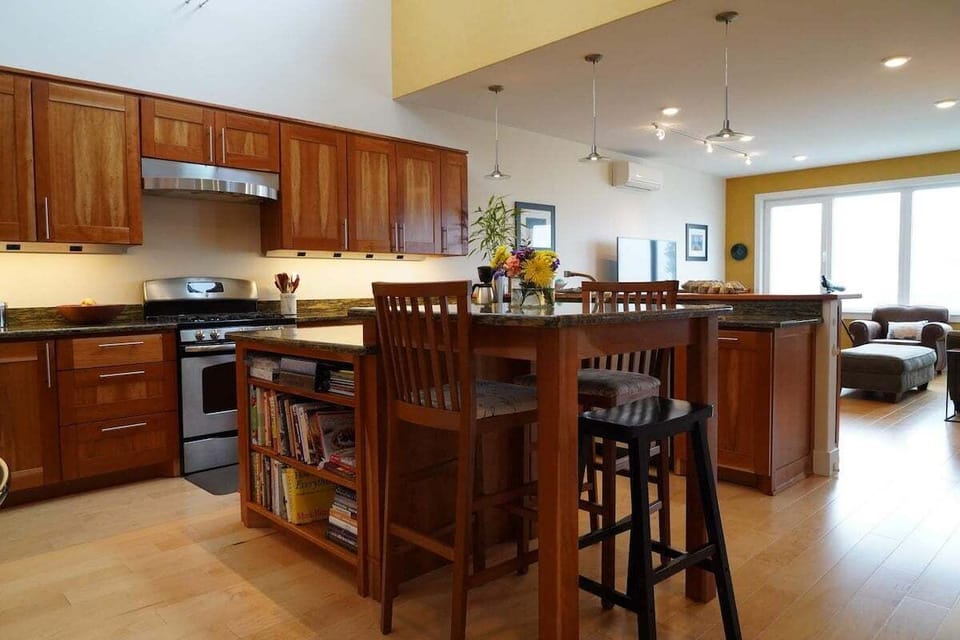 Bright, open kitchen for gathering 🍽️

This spacious kitchen features warm wood cabinetry, modern appliances, and a large island perfect for cooking, dining, or sharing a glass of wine. With the living area just steps away, it's an inviting space for meals, conversation, and time together.