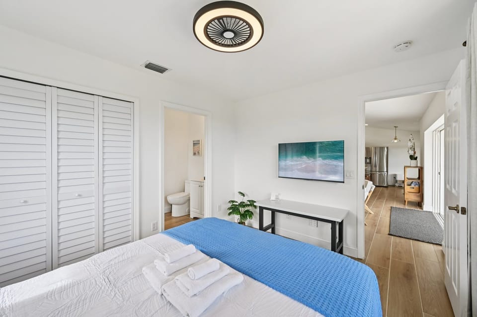 Comfortable bedroom with TV, closet, and easy access to a shared bathroom.