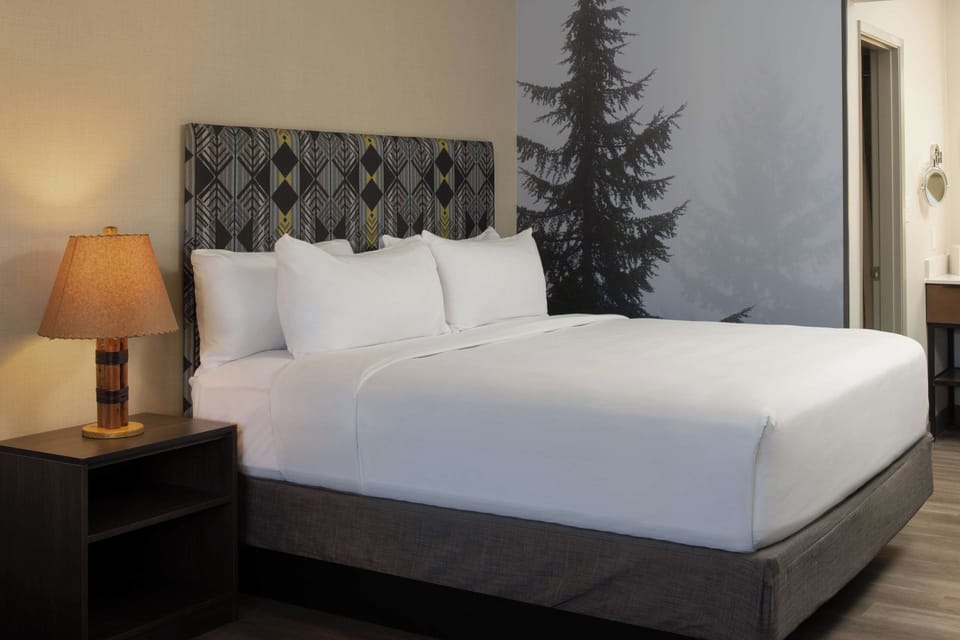 Unwind in crisp linens beneath a bold, modern headboard.