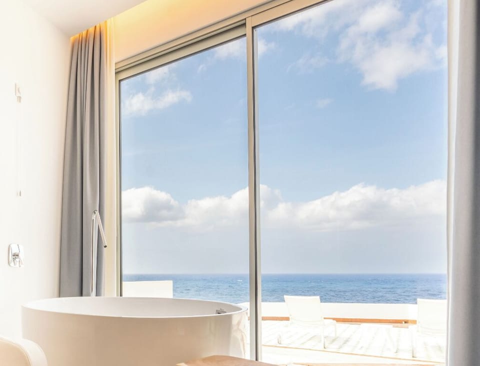 Bask in golden daylight with panoramic sea beyond glass.