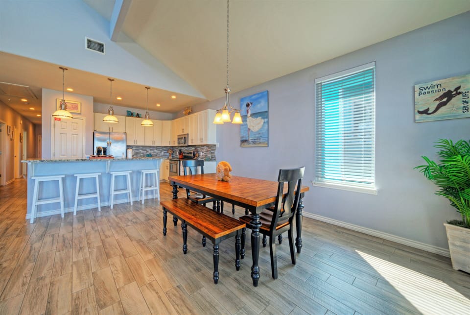 Airy dining space with an open kitchen, breakfast bar seating, and plenty of room to gather after a beach day.