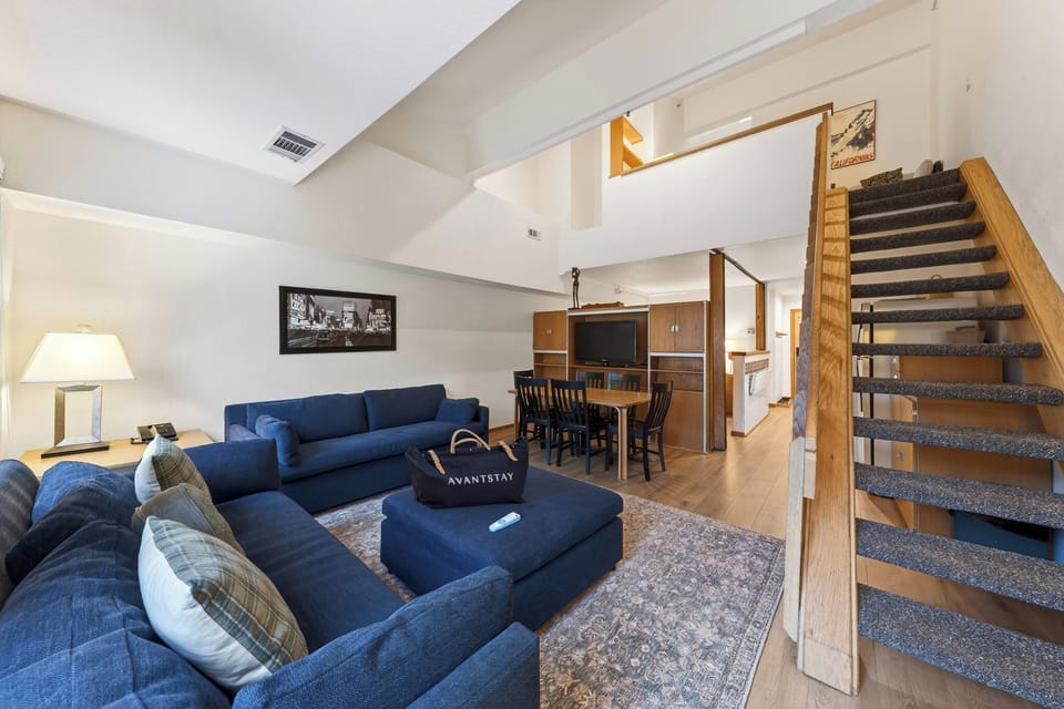 Bright and inviting living space with 2 sleeper sofas, vaulted ceilings, and large windows that bring in natural light and treetop views. (The Traverse)