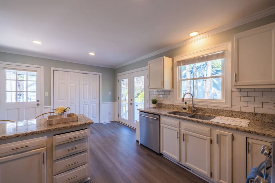 Bright kitchen with granite counters, double sink, and deck access.