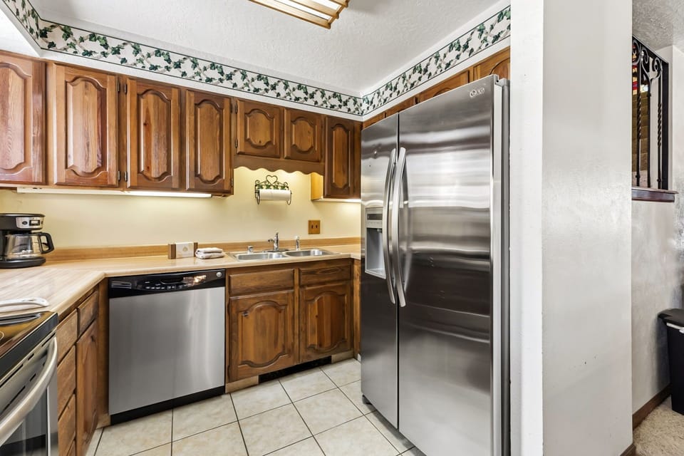 Your fully equipped kitchen features rich wood cabinetry, stainless steel appliances, and everything needed to prepare memorable meals during your stay.