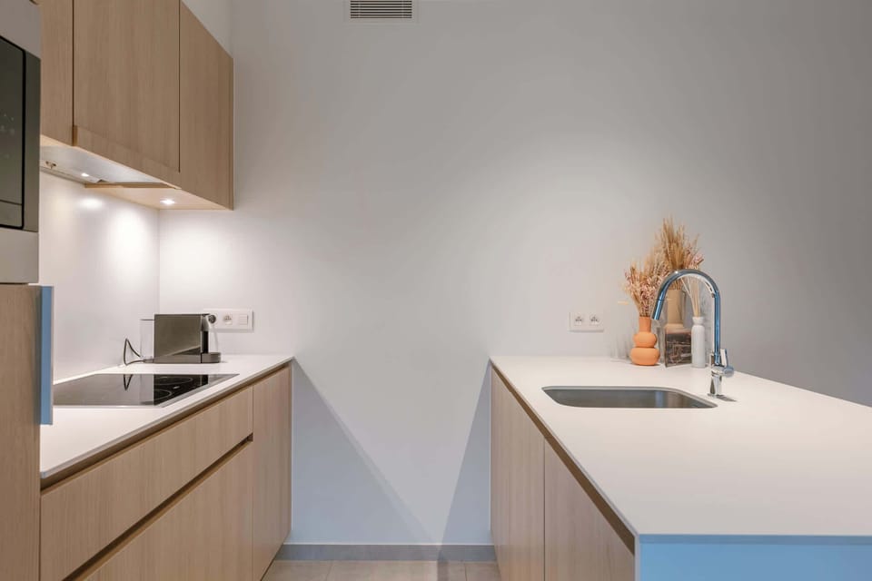 A warm, open-plan living space with a fully equipped kitchen and a dining table for four