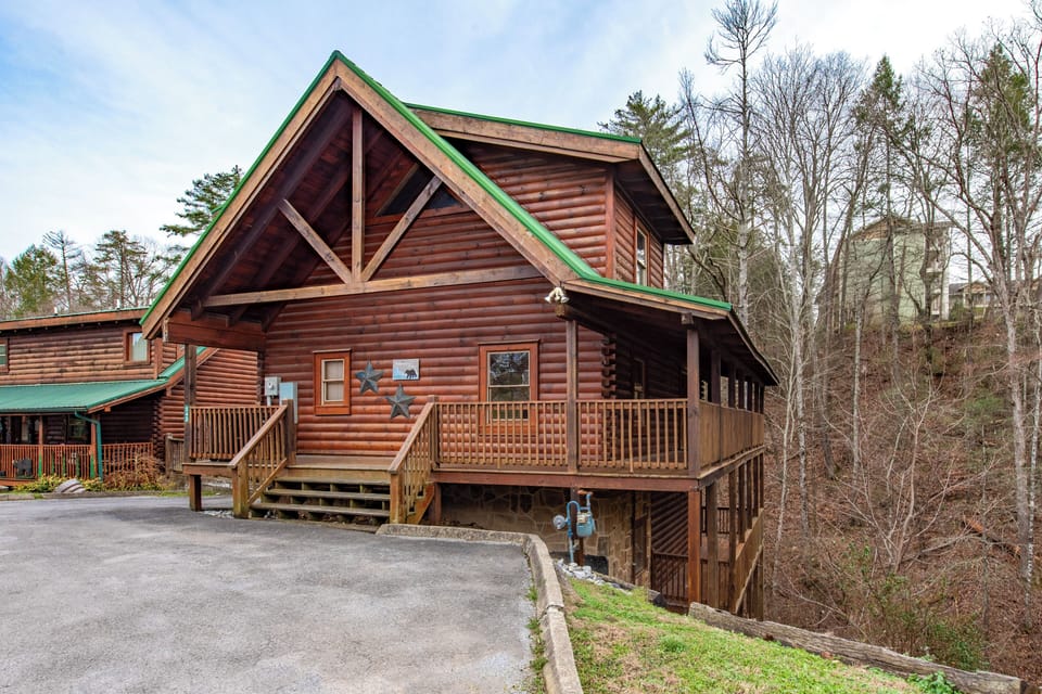 Rustic log cabin retreat nestled among towering trees, featuring a spacious deck and mountain charm for the perfect getaway.