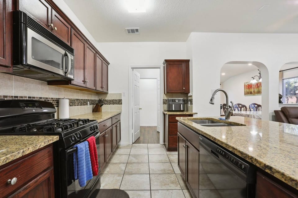 Kitchen with granite countertops, microwave, air fryer, oven, dishwasher