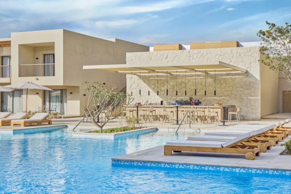 Lounge poolside and sip cocktails at the sunlit swim-up bar