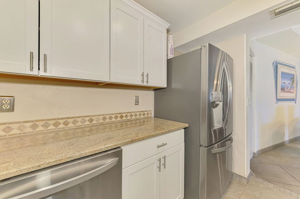 Your fully equipped kitchen features granite counters, stainless appliances, and crisp white cabinetry for effortless meal preparation.