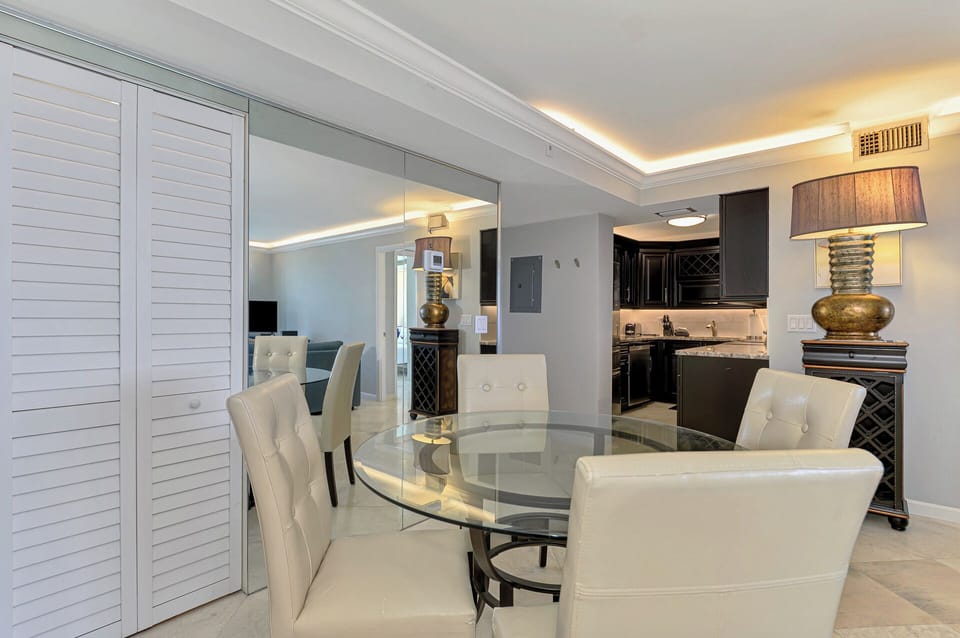 Gather around your elegant glass dining table, where sophisticated white leather chairs create the perfect setting for memorable meals.
