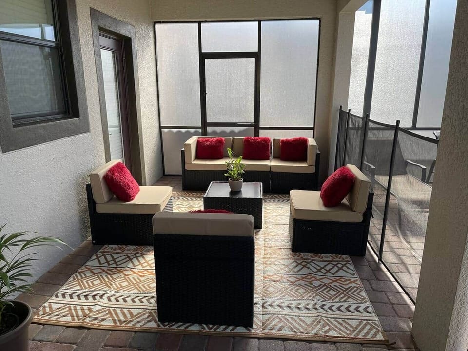 Profitez de la terrasse élégante avec coin repas, fauteuils confortables et barbecue pour des moments conviviaux sous le soleil de Floride.