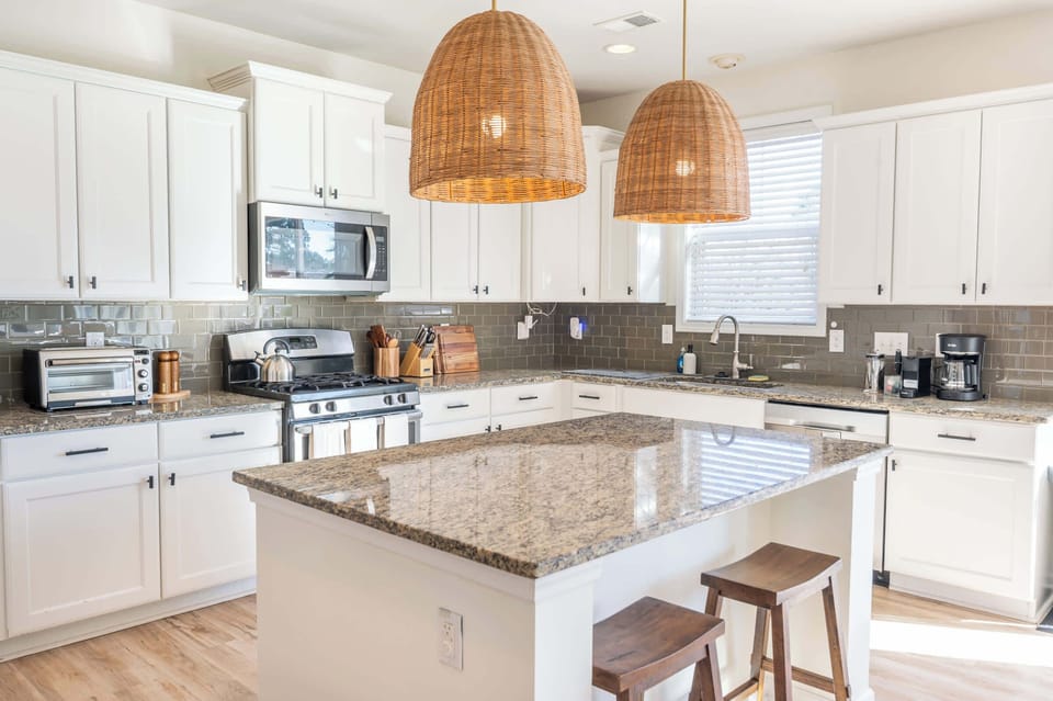 Spacious island kitchen with granite countertops and stylish pendant lighting.