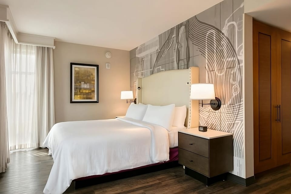 Sink into plush bedding beneath bold, modern feature walls.