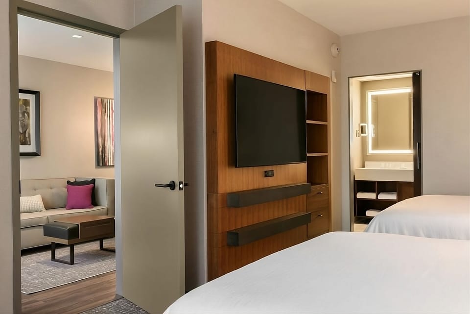 Unwind in a bright bedroom with TV, lounge, and vanity.