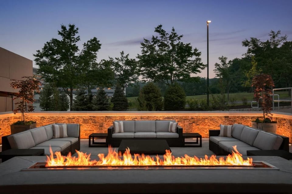 Gather by the fire under twilight skies and cozy seating.