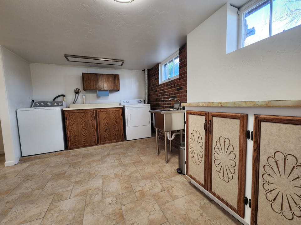 Laundry room with washer/dryer, deep sink, iron & ironing board, clothes steamer