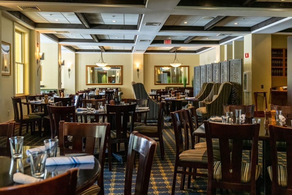 Warm wood tones and soft lighting create a cozy, inviting atmosphere inside Coleman Brook Tavern—perfect for après-ski dining and conversation.