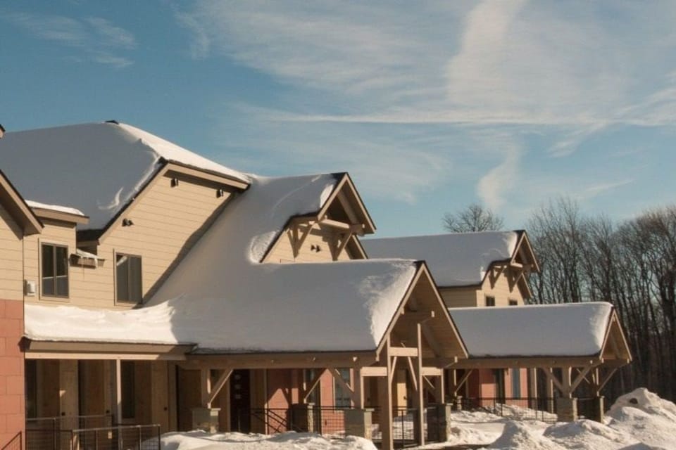 Nestled under a soft blanket of snow, the charming architecture of South Face Village Condominiums beckons guests to experience the serenity of winter in the heart of Vermont's picturesque Okemo Mountain.