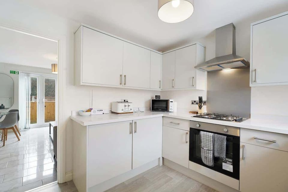 Kitchen equipped with all essentials, including a washer, gas hob, oven, fridge, microwave, kettle, toaster, and full cookware set.