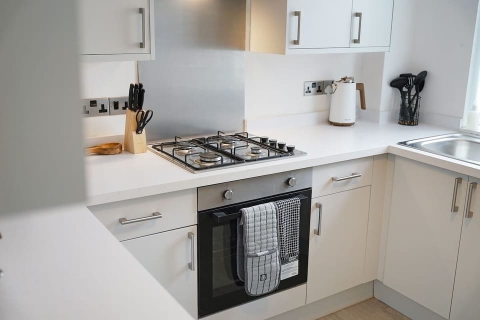 Kitchen equipped with all essentials, including a washer, gas hob, oven, fridge, microwave, kettle, toaster, and full cookware set.