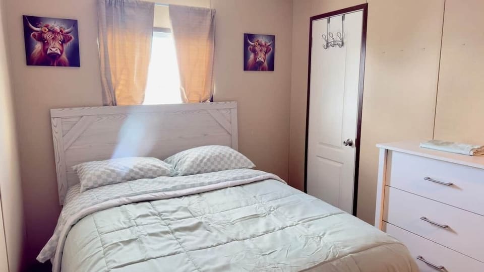 Comfortable queen bedroom with dresser and closet.