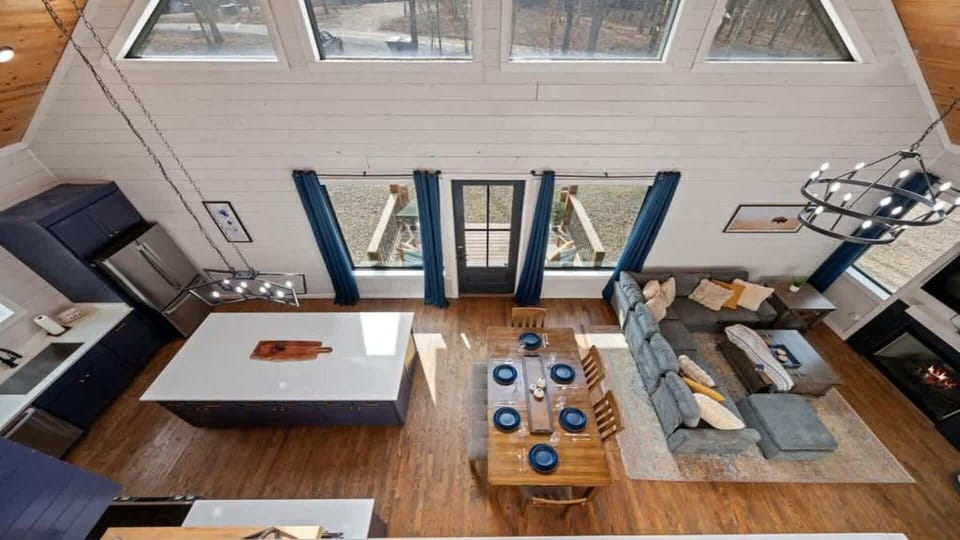 Open-concept cabin with vaulted ceilings, modern kitchen, and cozy living area