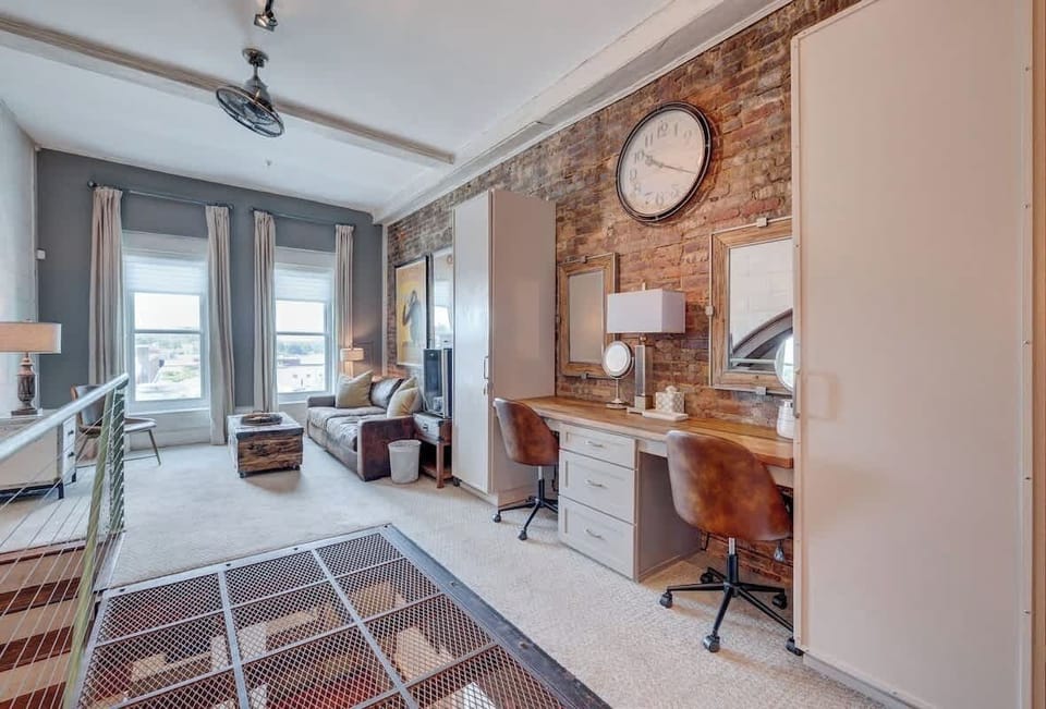 Industrial Chic Retreat: Sleek furnishings meet exposed brick charm, perfect for relaxation and inspiration!