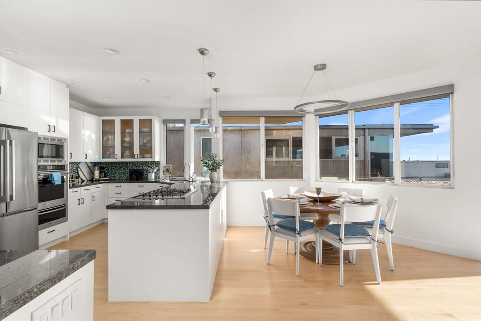 Open kitchen and dining area filled with natural light, offering a welcoming space for meals, conversation, and relaxed coastal living.
