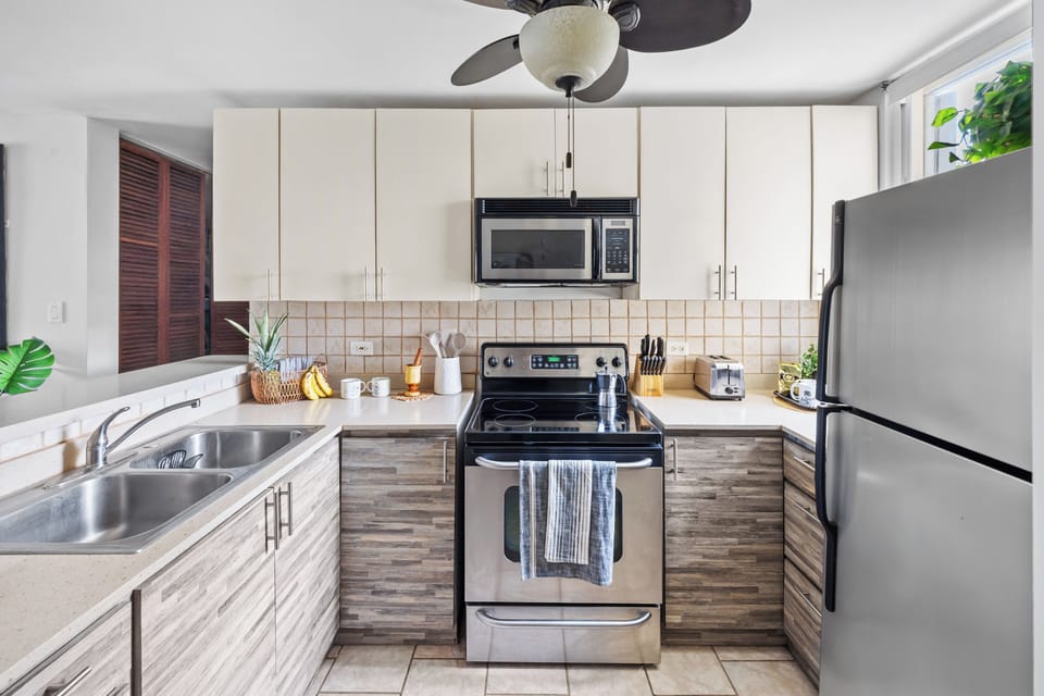 Well-equipped kitchen: microwave, stove, fridge, and garbage disposal.