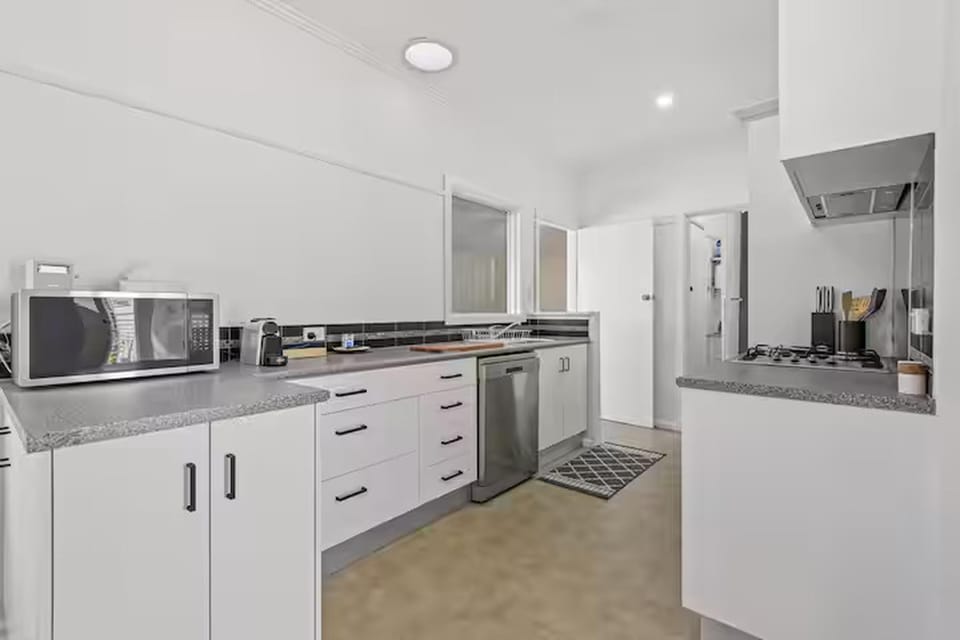 Bright, modern galley kitchen with gas cooktop, dishwasher and essentials