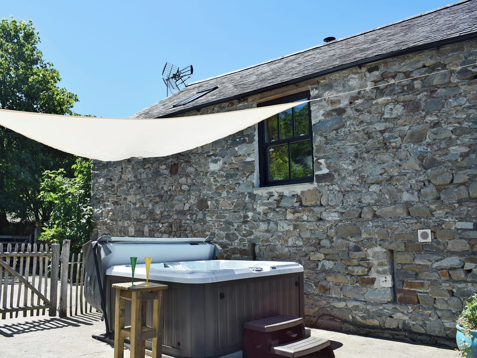 Impressive jacuzzi hot tub in courtyard | The Coach House Loft - Dolgoy Cottages, Llangrannog