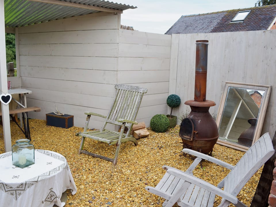 Courtyard with garden furniture, BBQ and chiminea | The Old Parlour - Cheshire Boutique Barns, Wrenbury, near Nantwich