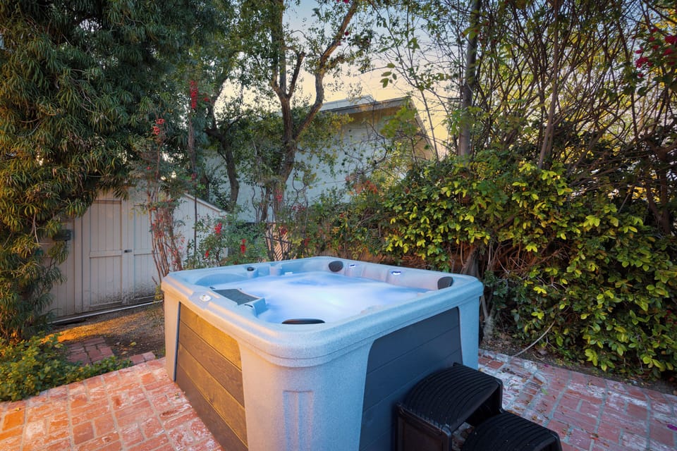 Unwind in the private hot tub, tucked among lush greenery—your perfect evening reset.
