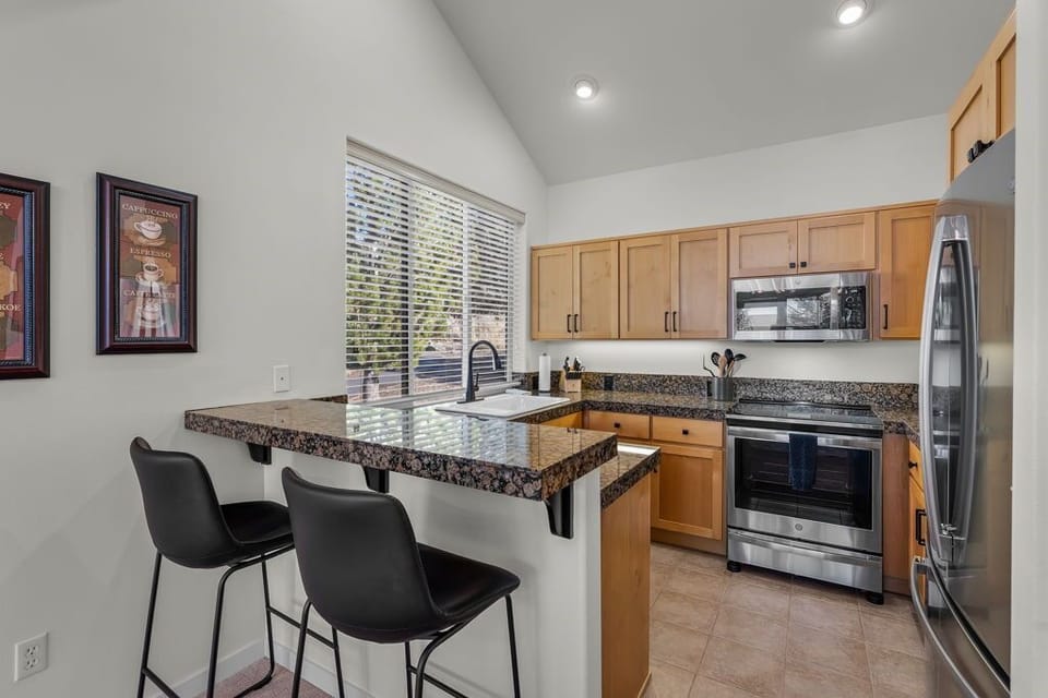 Your modern kitchen features granite countertops, stainless steel appliances, and a breakfast bar perfect for morning coffee or casual meals.