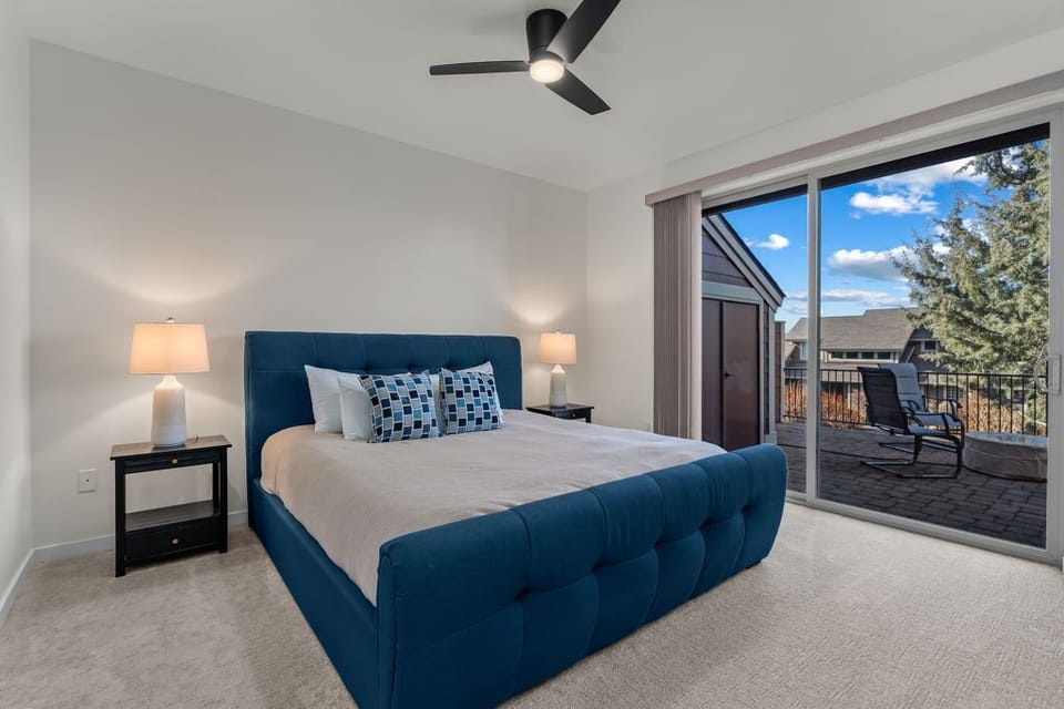 Sink into the plush blue bed and wake to stunning views through floor-to-ceiling windows opening to your private balcony.