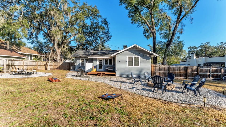 Spacious city backyard with outdoor games, fire pit, grill, and plenty of seating to relax and enjoy the Florida weather.