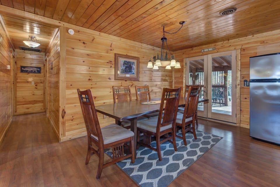 Gather around this beautiful wooden dining table where your family meals become cherished memories in this warm, rustic cabin atmosphere.