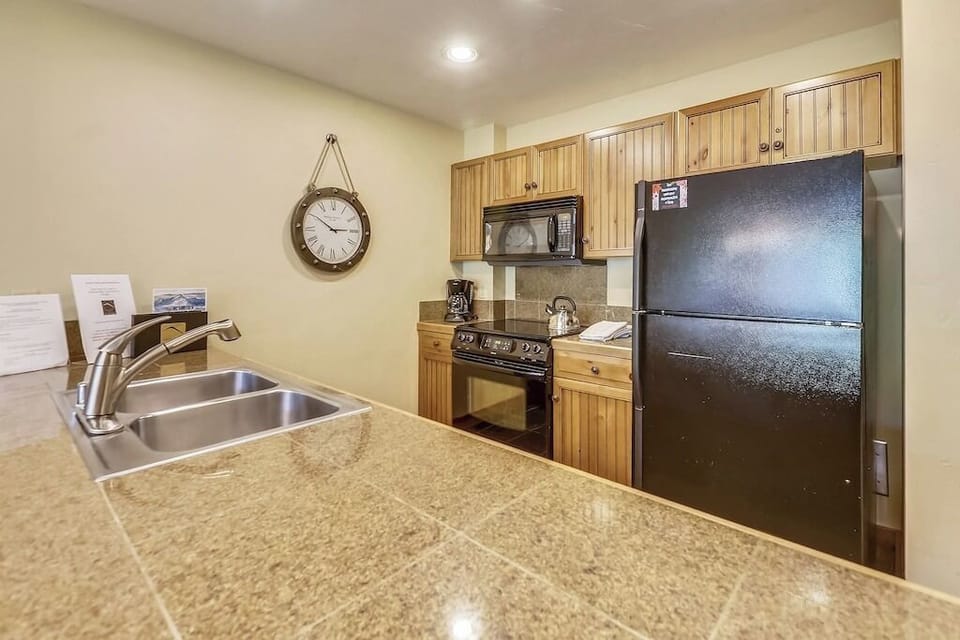 Your fully equipped kitchen features granite countertops, stainless steel appliances, and warm wood cabinetry for comfortable meal preparation.
