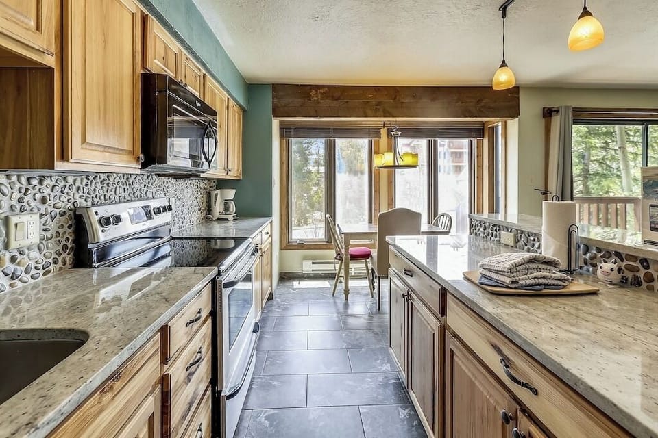 Your spacious kitchen features granite countertops, warm wood cabinetry, and stone backsplash creating the perfect space for memorable meals.