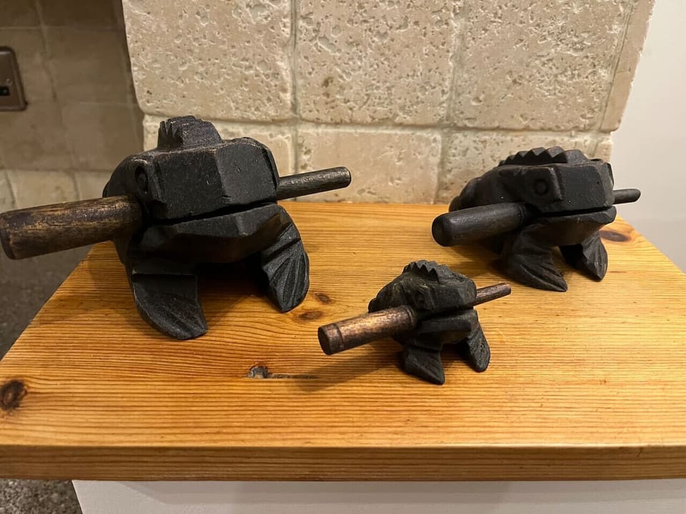 A decorative workbench displaying two old metal bench vices sits against an exposed stone wall, forming a character feature within the property.