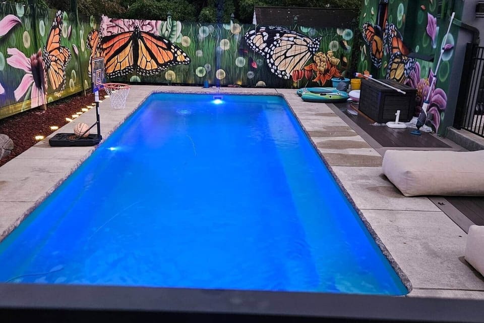 The custom painted butterfly and flower mural adds so much whimsy and fun to the beautiful pool area