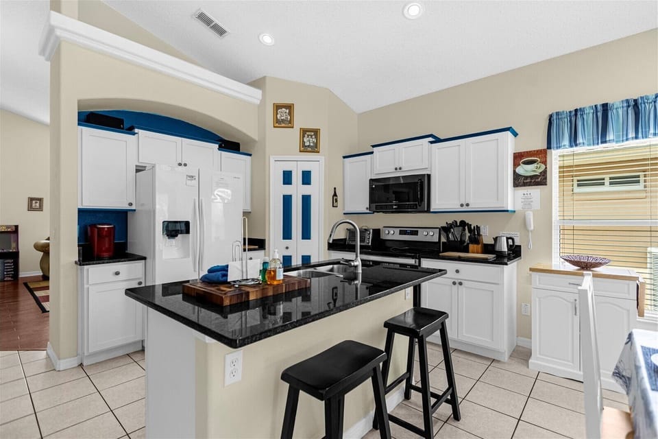 Kitchen Area With Full Size Fridge, Shove, And Microwave