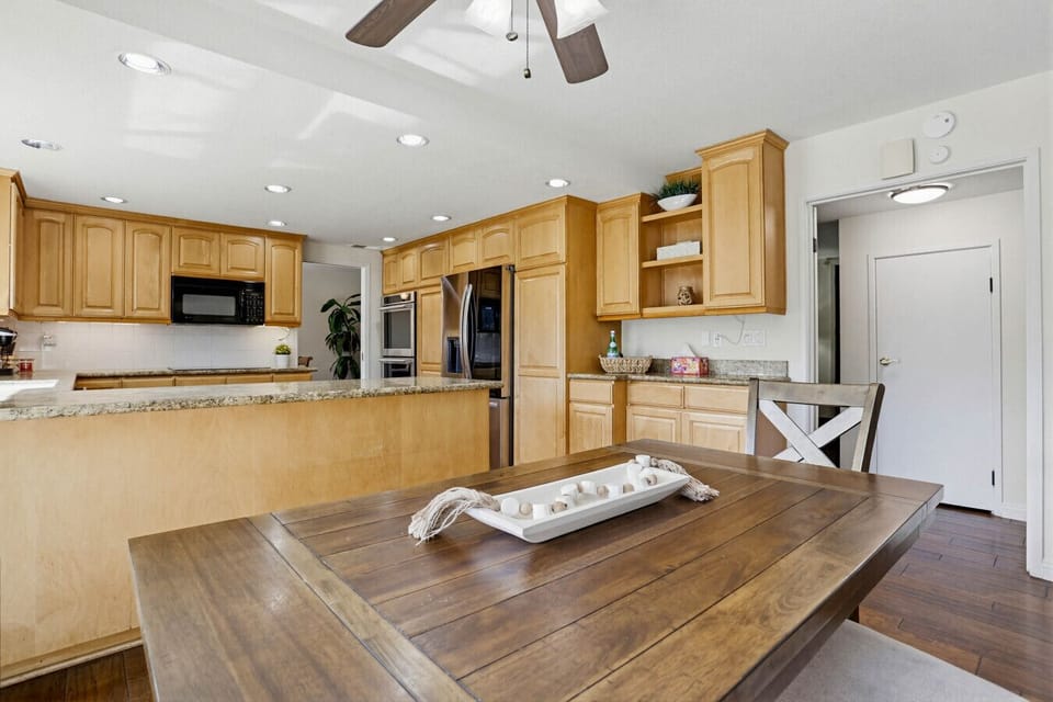Spacious kitchen w/ wood cabinetry, ample counter space & open layout for easy cooking