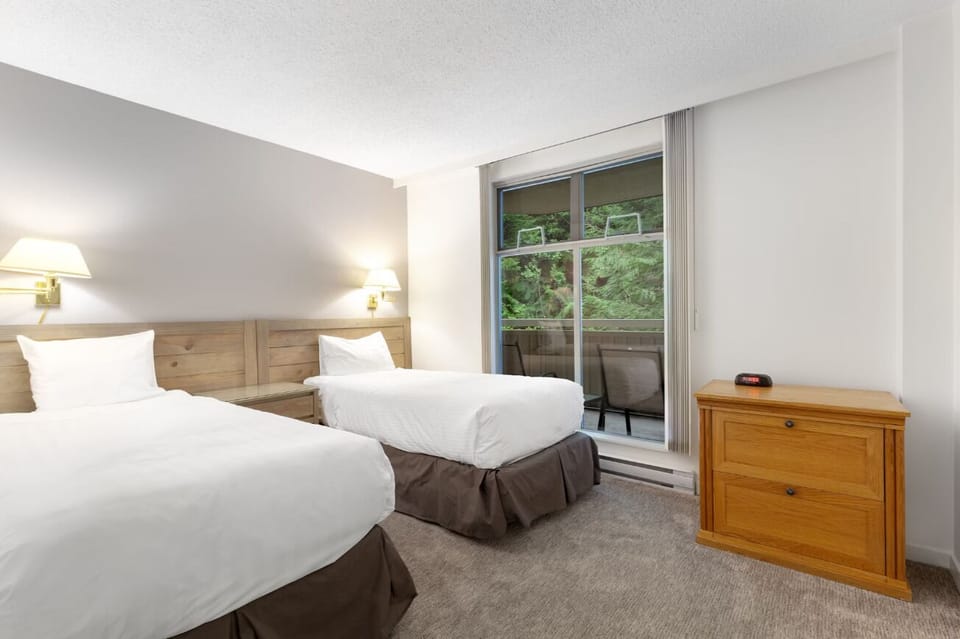 Drift off in cozy twin beds beside balcony light.
