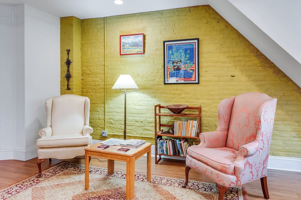 Living Room Retreat: Bright space with unique art, comfy seating, and warm yellow walls awaits!